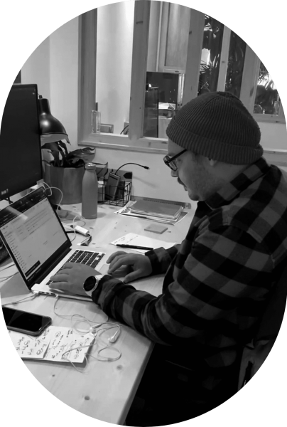 Photo en noir et blanc d'un homme en train de travailler à son bureau.